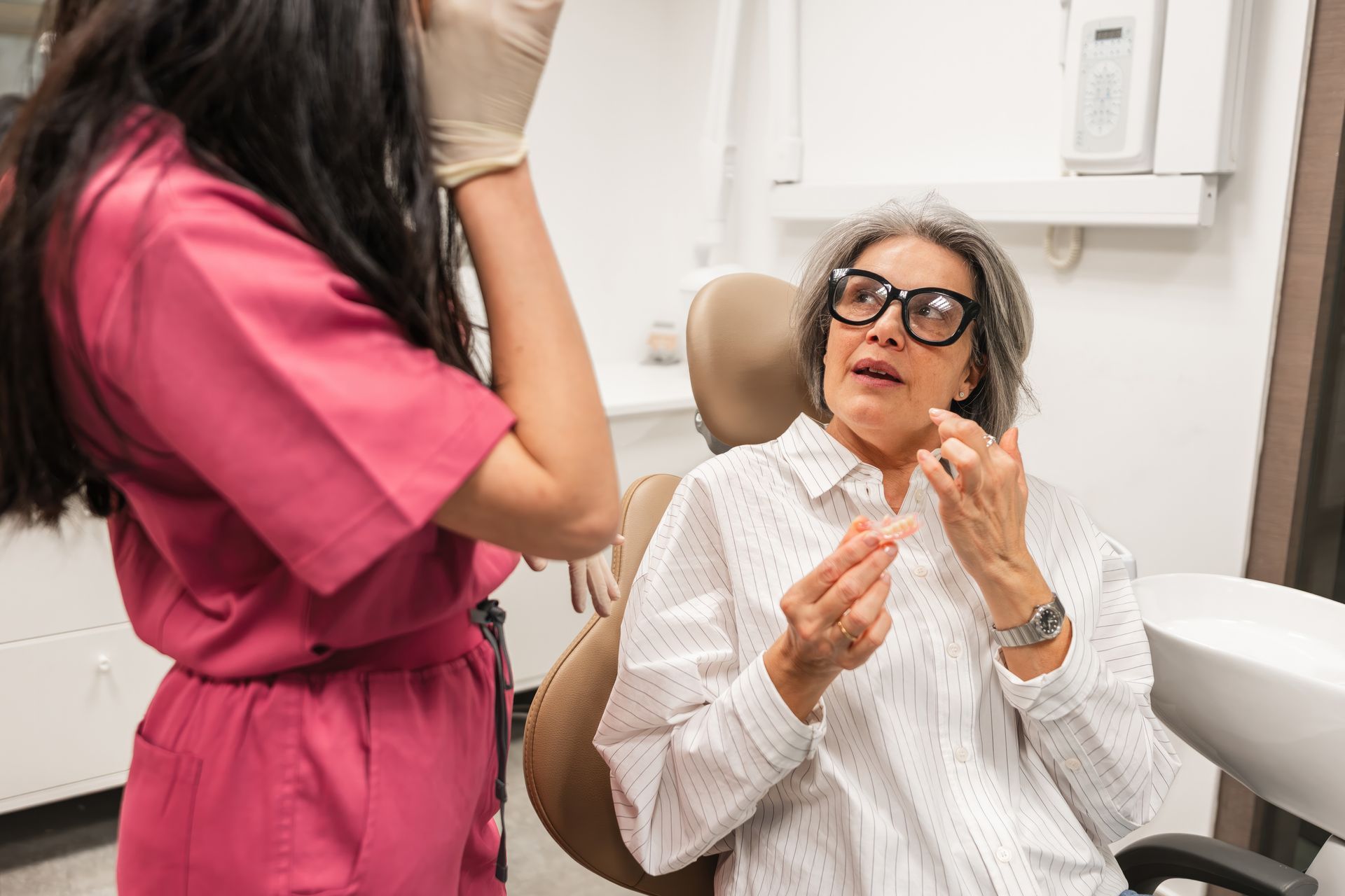 Patient speaking with dentist during checkup in a bright dental clinic