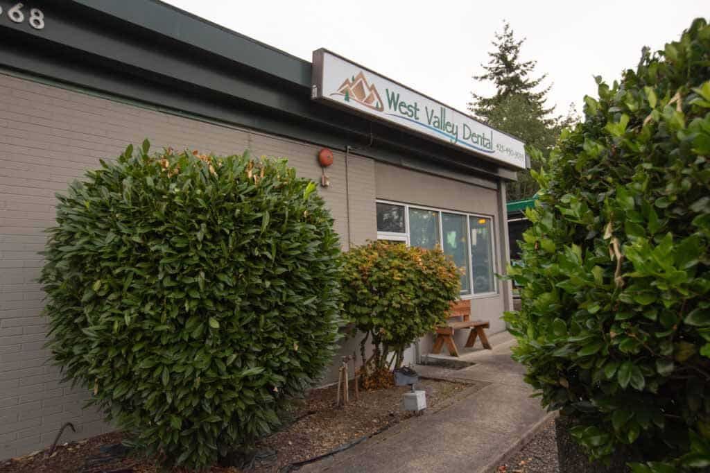 West Valley Dental office exterior with shrubbery and sign.