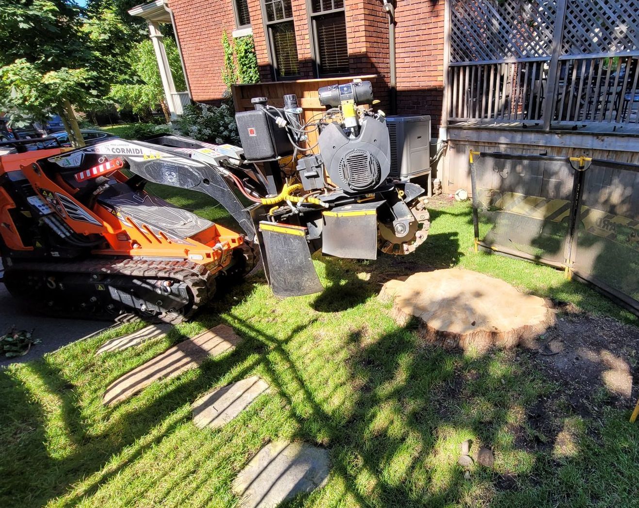 Un tracteur est assis à côté d'une souche d'arbre dans une cour.