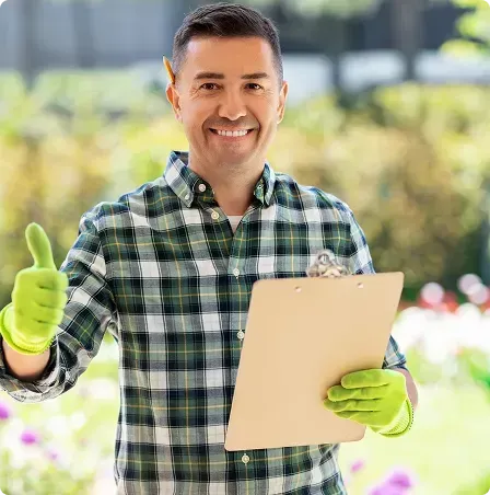 Un homme en chemise à carreaux tient un presse-papiers et lève le pouce.