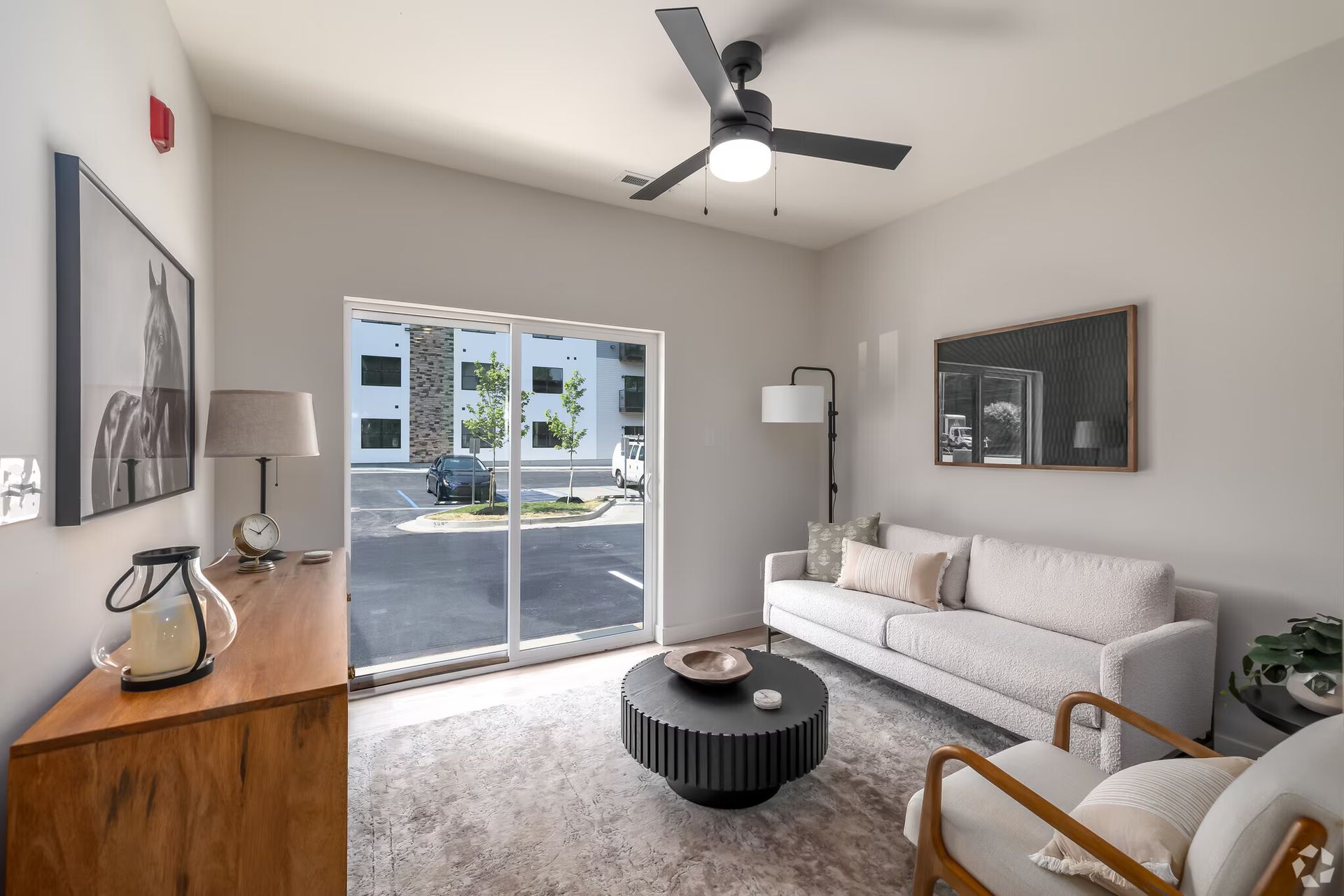 Photo of a living room, showing the parking lot outside