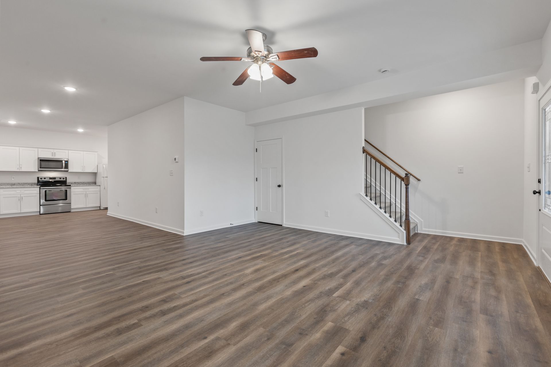 Photo of a large living room with the kitchen in the background