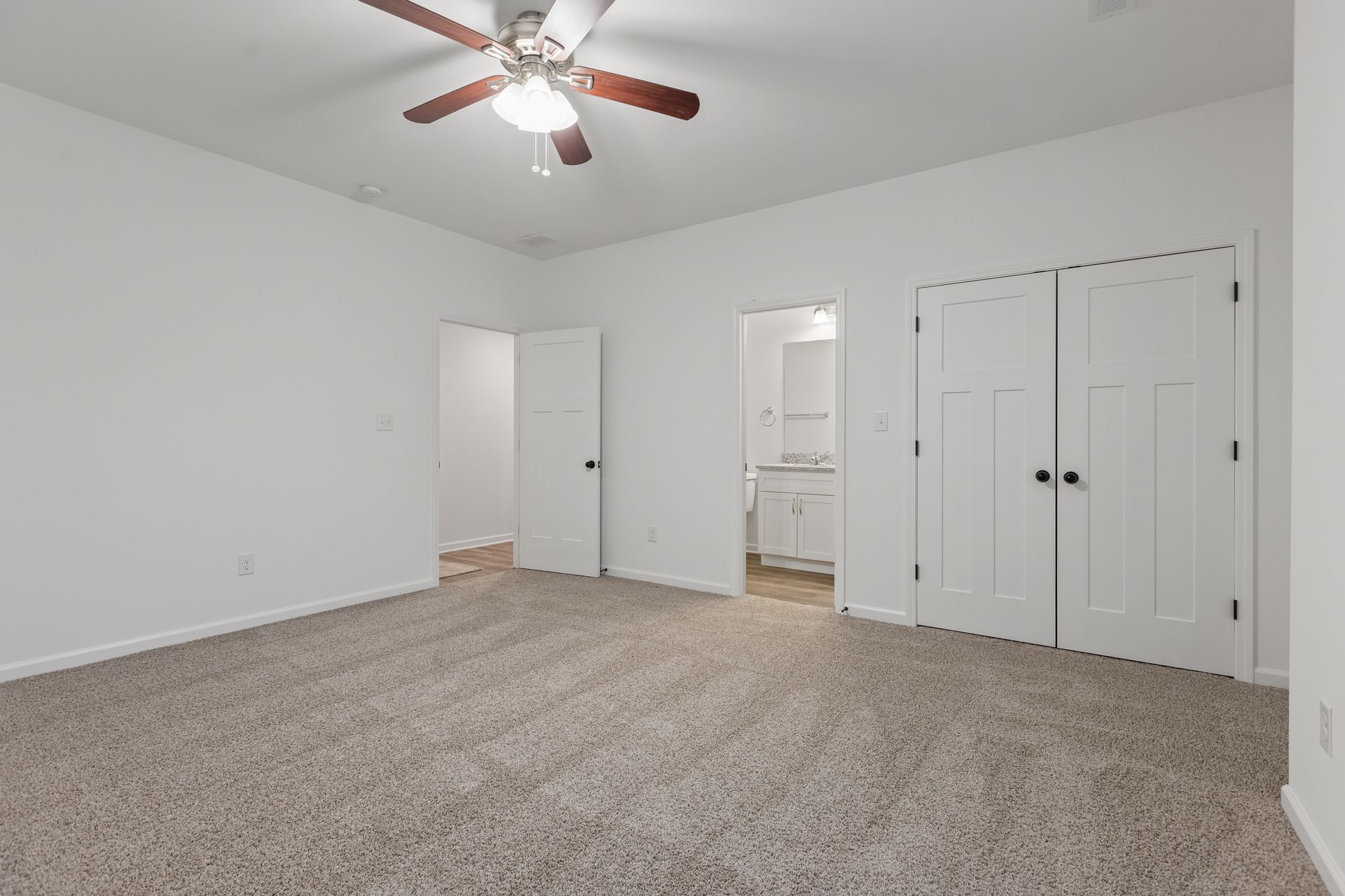 Photo of a master bedroom with the bathroom door open