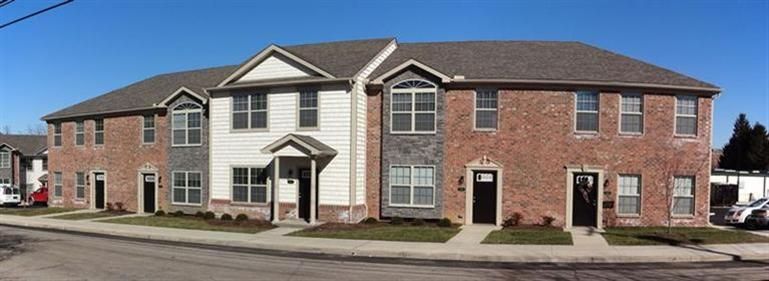 Photo of a multi-color, multi-material building with multiple front doors