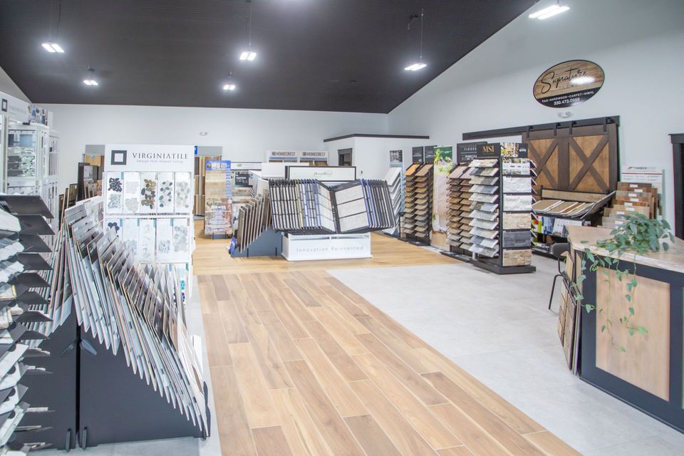 Interior of a flooring showroom with wood and tile samples on display.