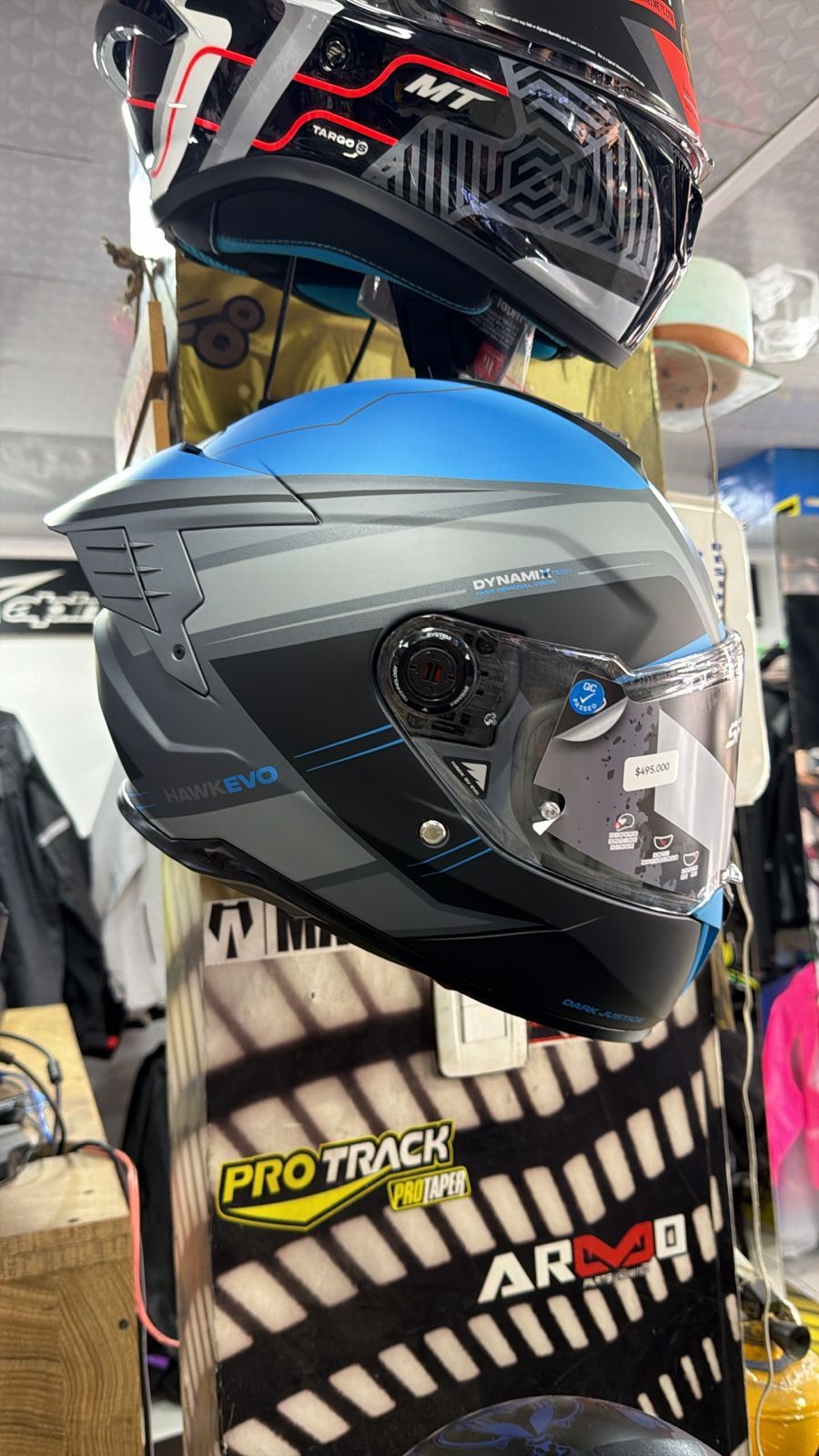 Casco de motocicleta azul y gris con visera, expuesto en una tienda.
