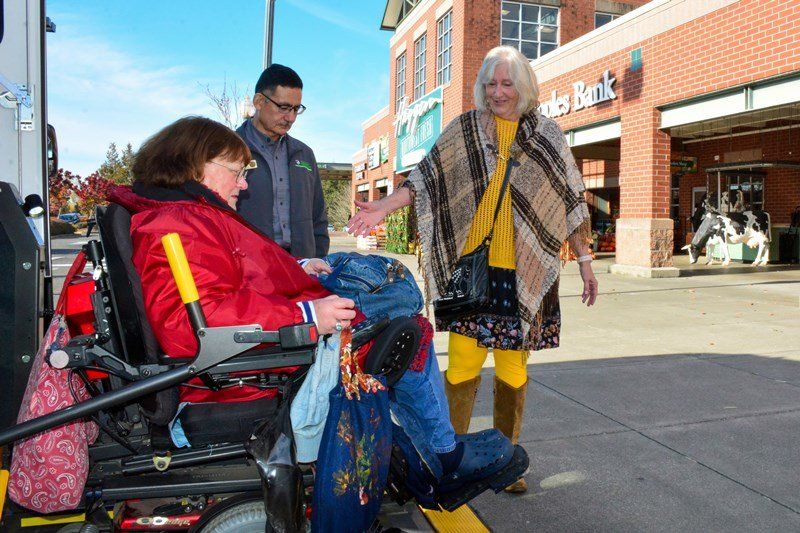 a woman in a wheelchair is being loaded into a bus .