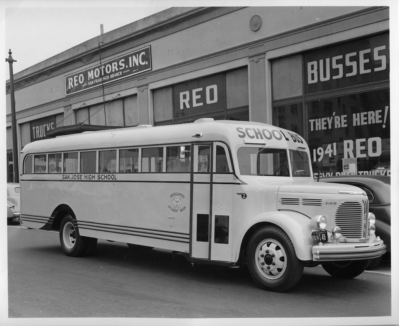a school bus is parked in front of a building that says red motors inc.