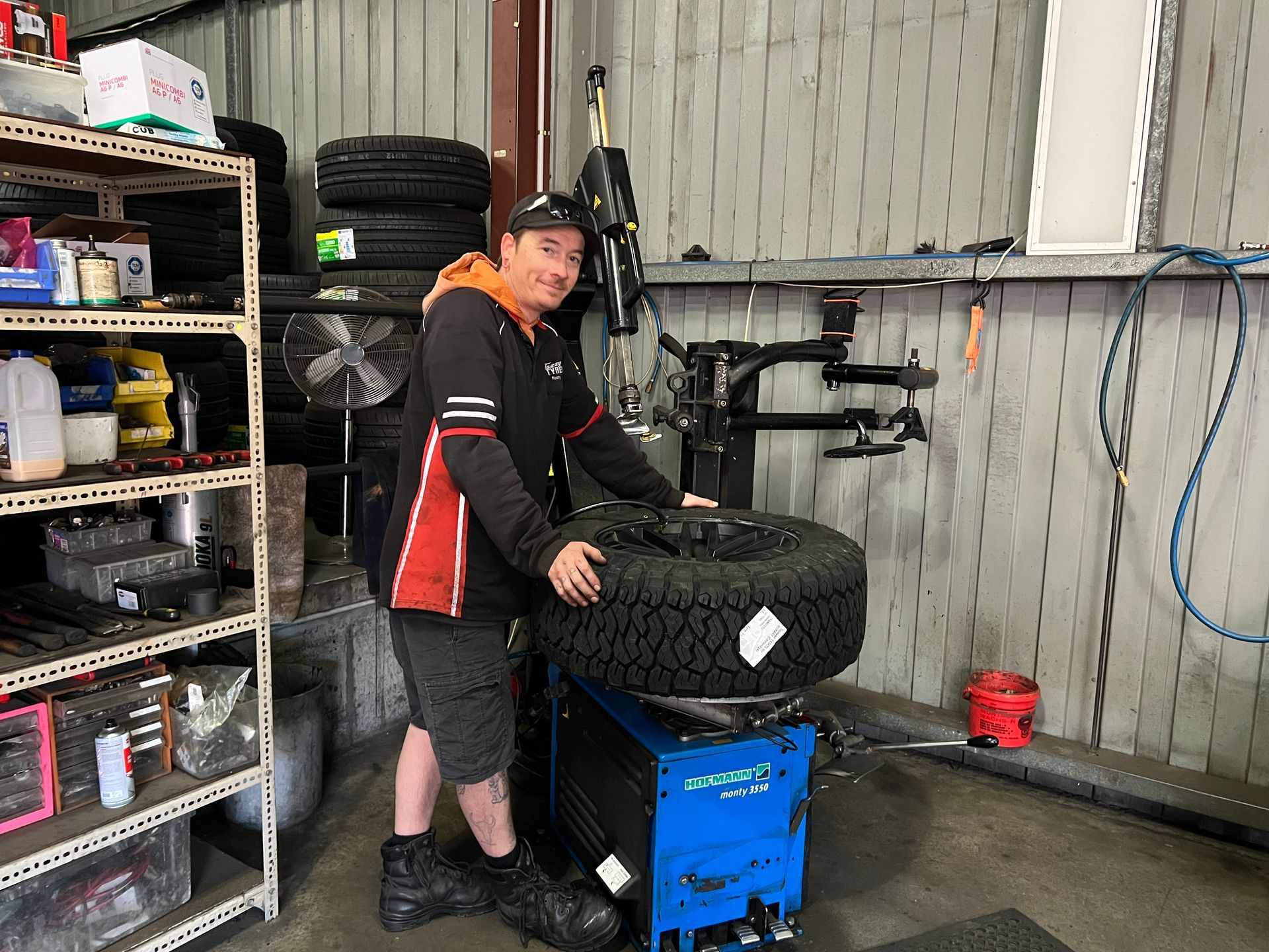 Mechanic changing a tire on a machine in a garage.