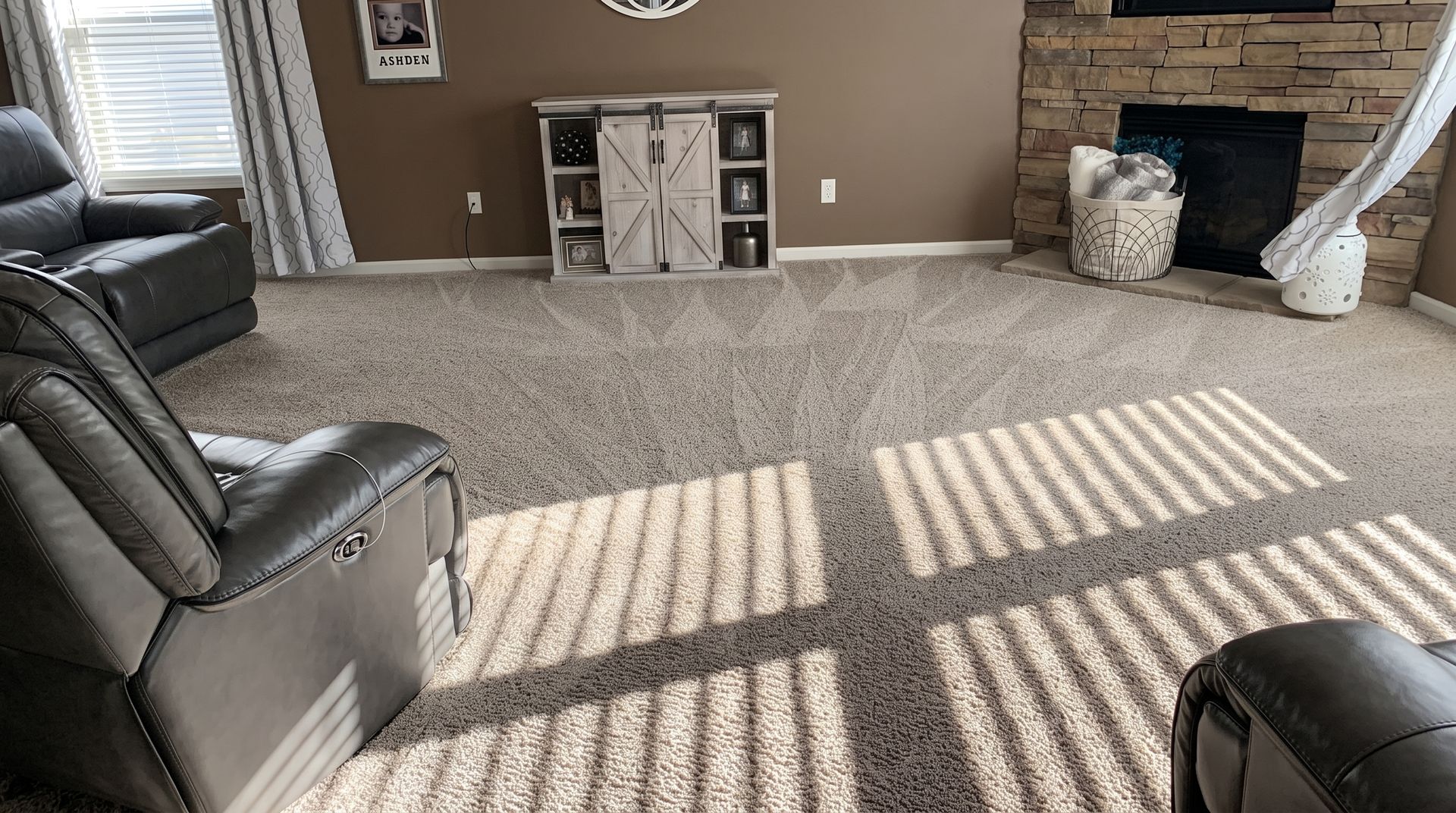 Vacuum cleaner head on beige carpet, cleaning a lighter rectangular patch