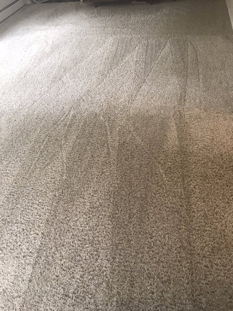 Close-up of a beige textured carpet with light and shadow across the surface