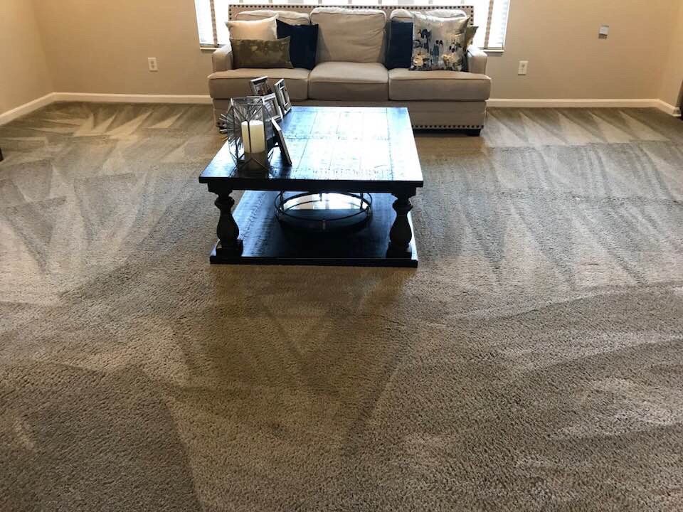 Living room with beige sofa, dark coffee table, and gray carpet