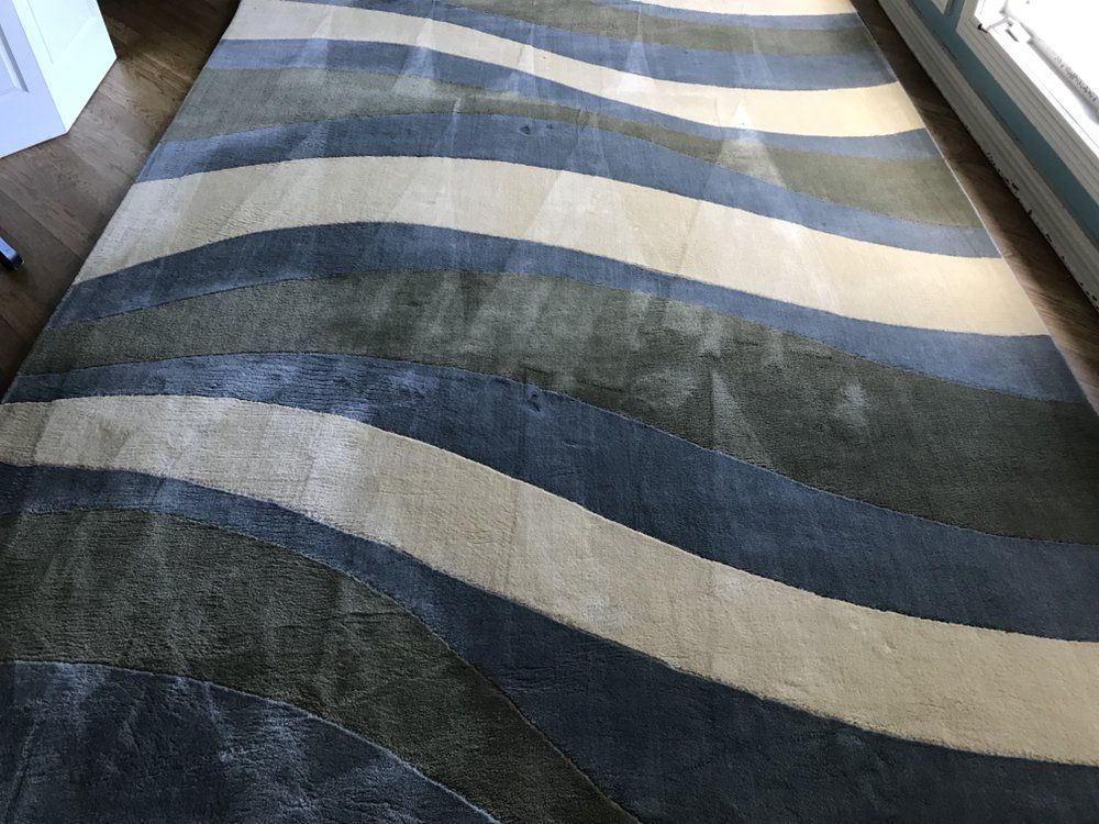 Blue, cream, and gray striped rug laid on the floor.