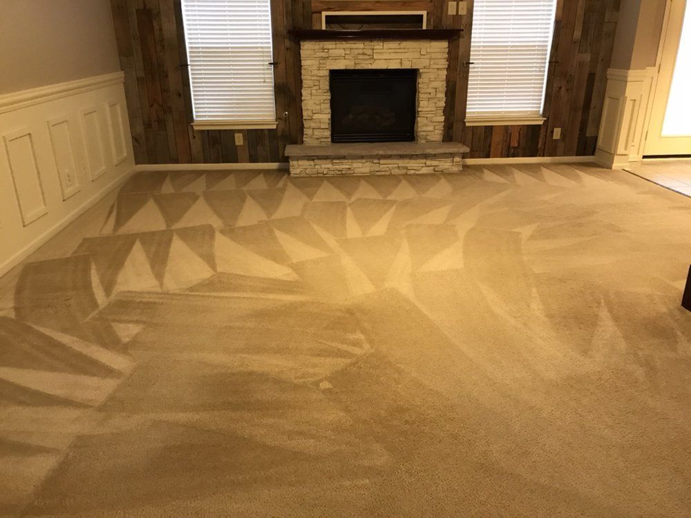 Living room with beige carpet, brick fireplace, and white paneled walls.