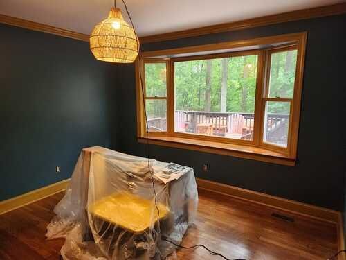 A room with a large window and a table covered in plastic.