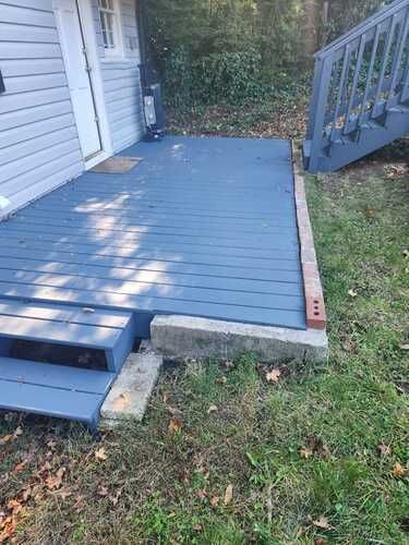 A blue deck with stairs next to a house.