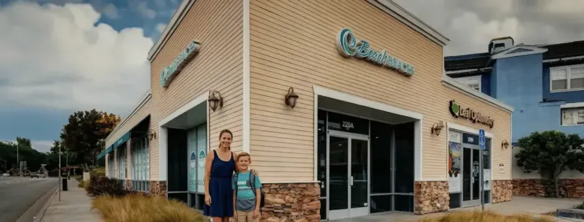 Two people standing outside a corner storefront with large glass windows and a blue sign