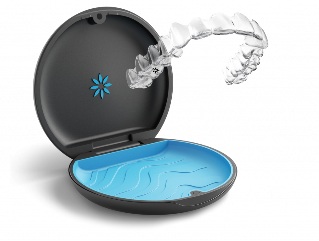 Open cosmetic compact with blue liquid splash and powder puff inside