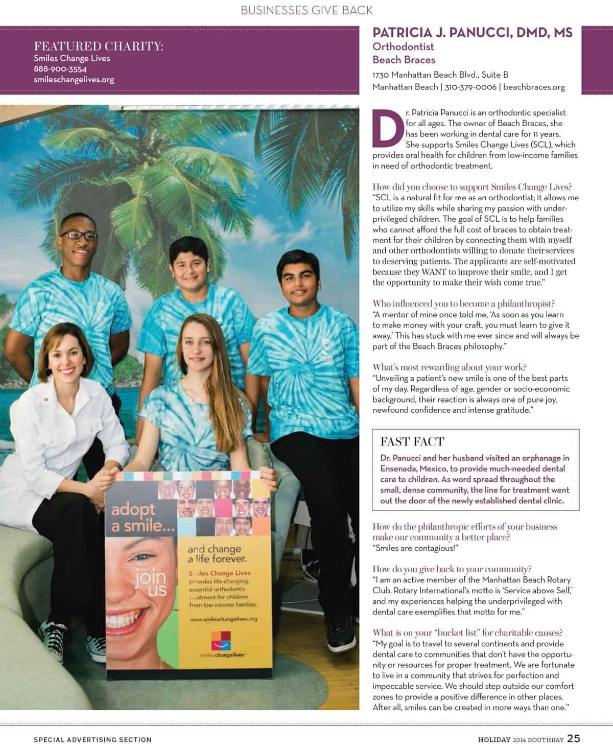Five people in blue Hawaiian shirts pose in front of a palm-tree mural beside a magazine cover display.