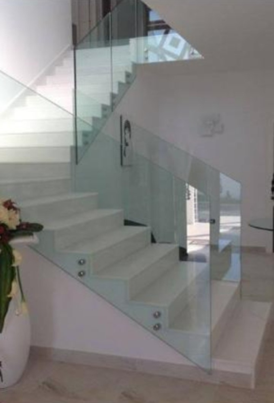 Scala moderna in vetro bianco con gradini sospesi in un interno luminoso