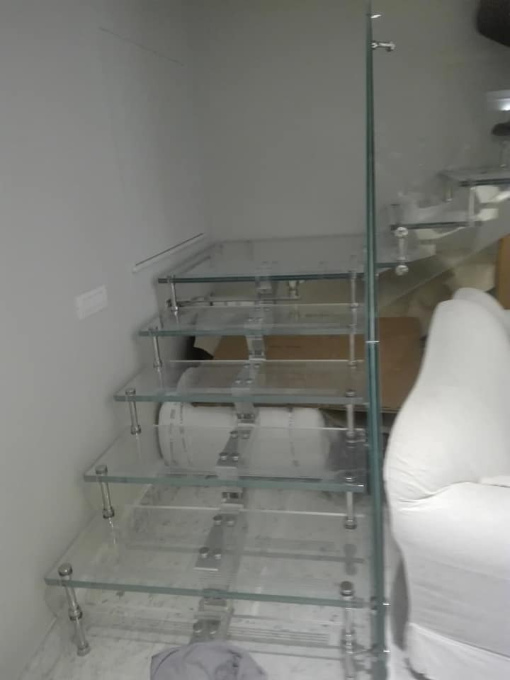 Mensola in vetro con asciugamani piegati in un angolo pulito del bagno.