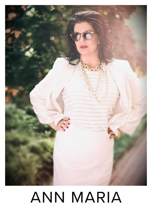 Woman in white outfit and sunglasses posing outdoors with the name “ANN MARIA” below.