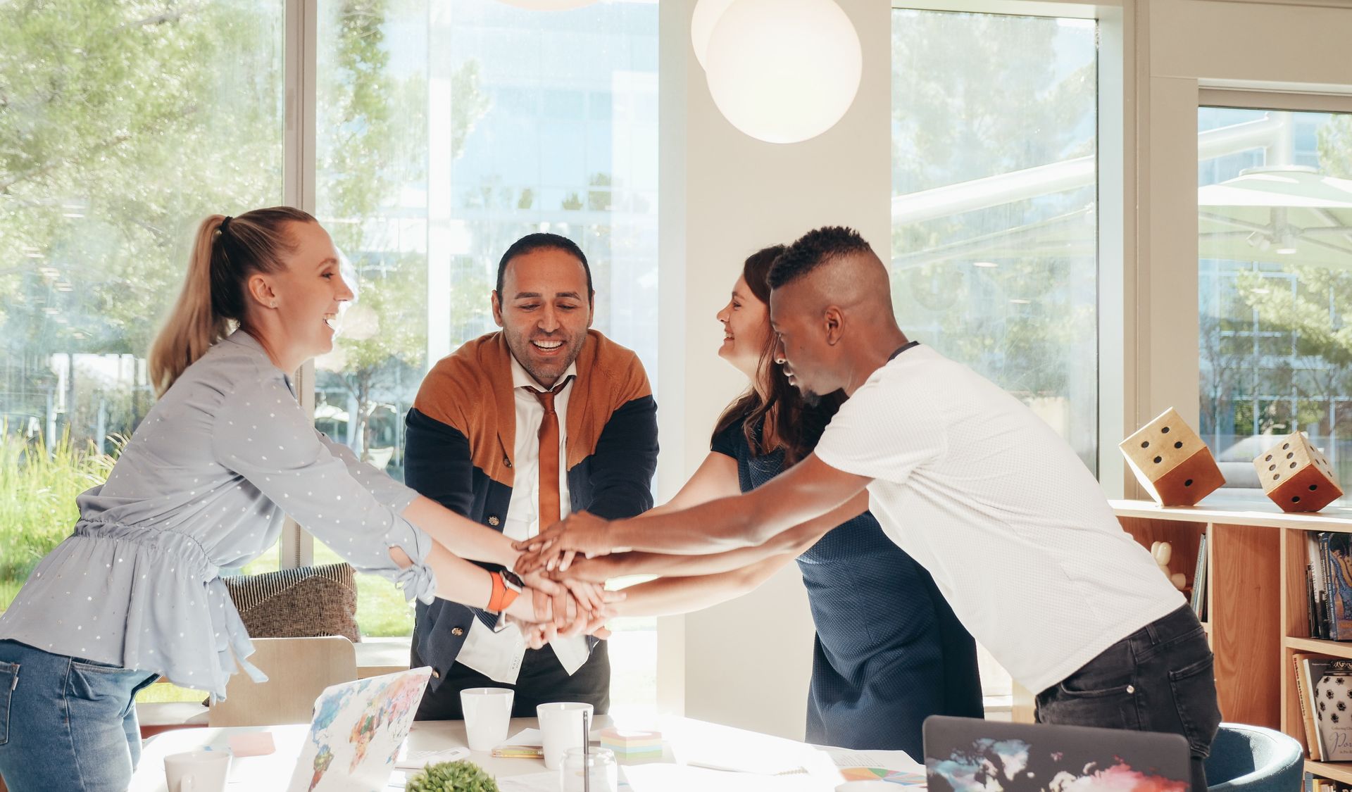 a group of people are putting their hands together in an office .