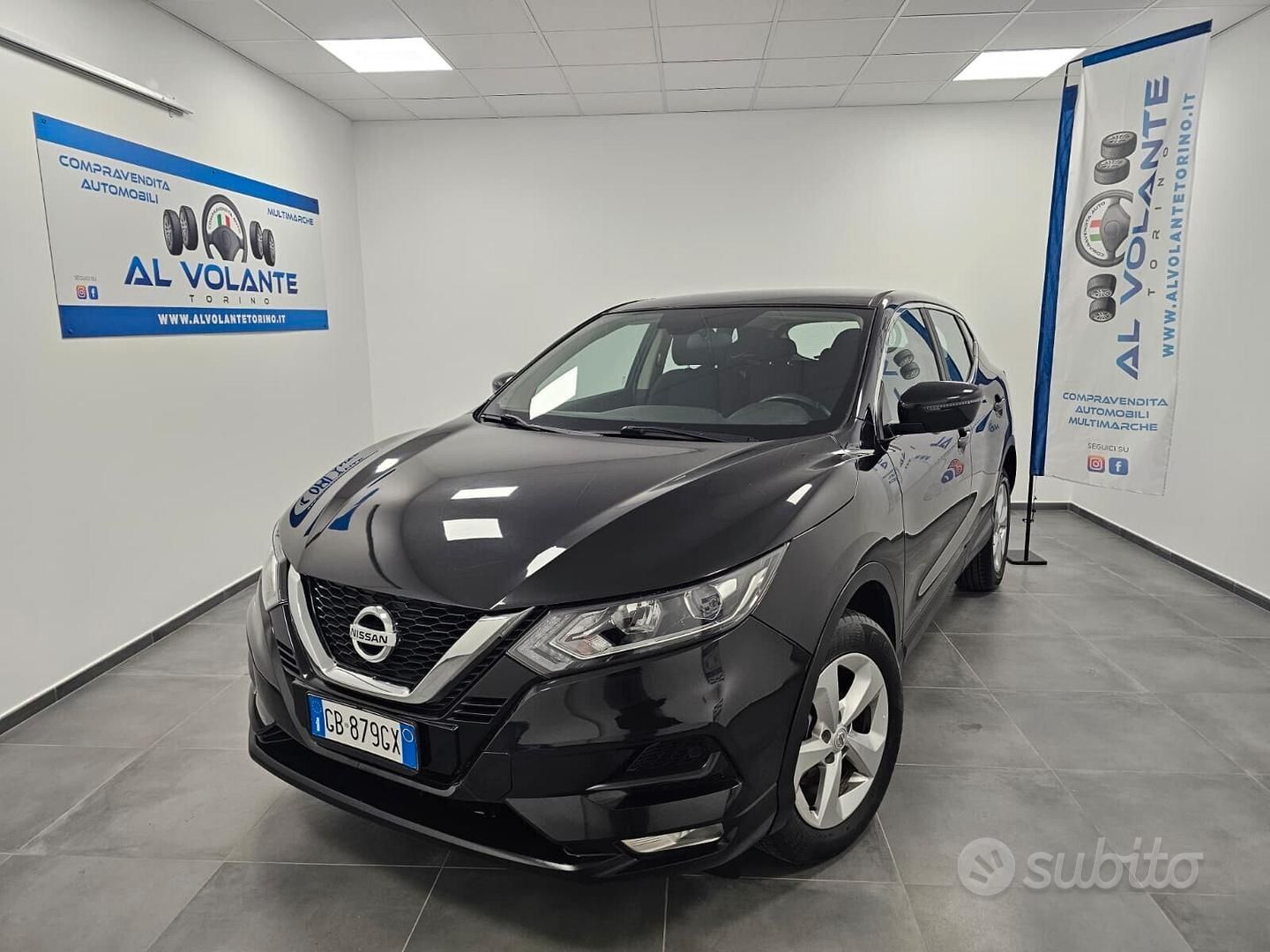 Una Lancia Ypsilon color argento parcheggiata in uno showroom ben illuminato, con il logo della concessionaria sulle pareti bianche.