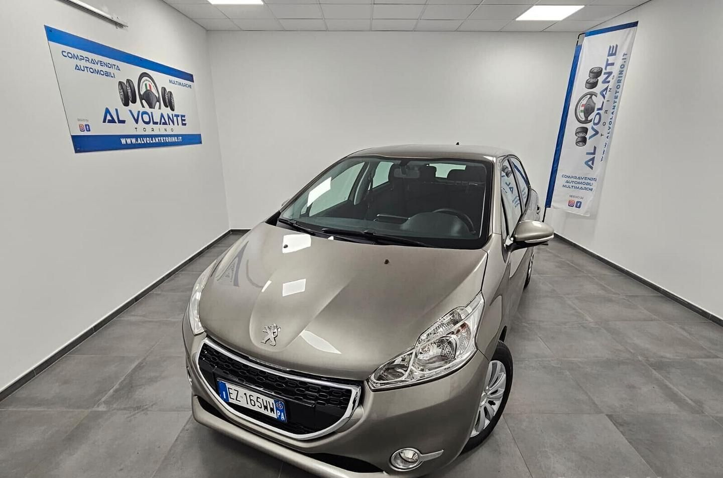 Un SUV Peugeot 2008 rosso parcheggiato in uno showroom luminoso con pareti bianche e uno striscione sullo sfondo.