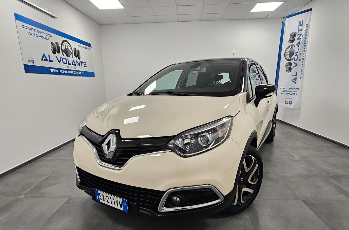 Una Fiat Panda bianca parcheggiata in uno showroom interno ben illuminato e piastrellato, con il marchio