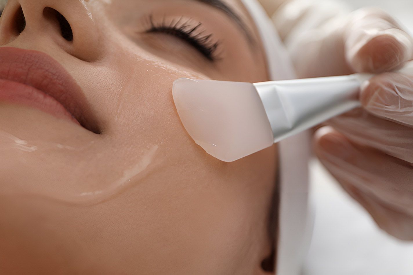 A Woman Is Getting A Facial Treatment With A Brush — Beauty Abode in Buderim, QLD