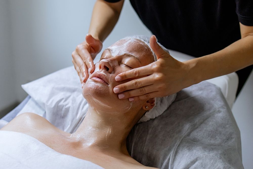 A Person Wearing Gloves Is Applying Something To Another Person's Face — Beauty Abode in Buderim, QLD