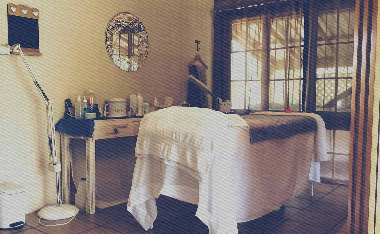 A Massage Table In A Room With A Mirror On The Wall — Beauty Abode in Buderim, QLD