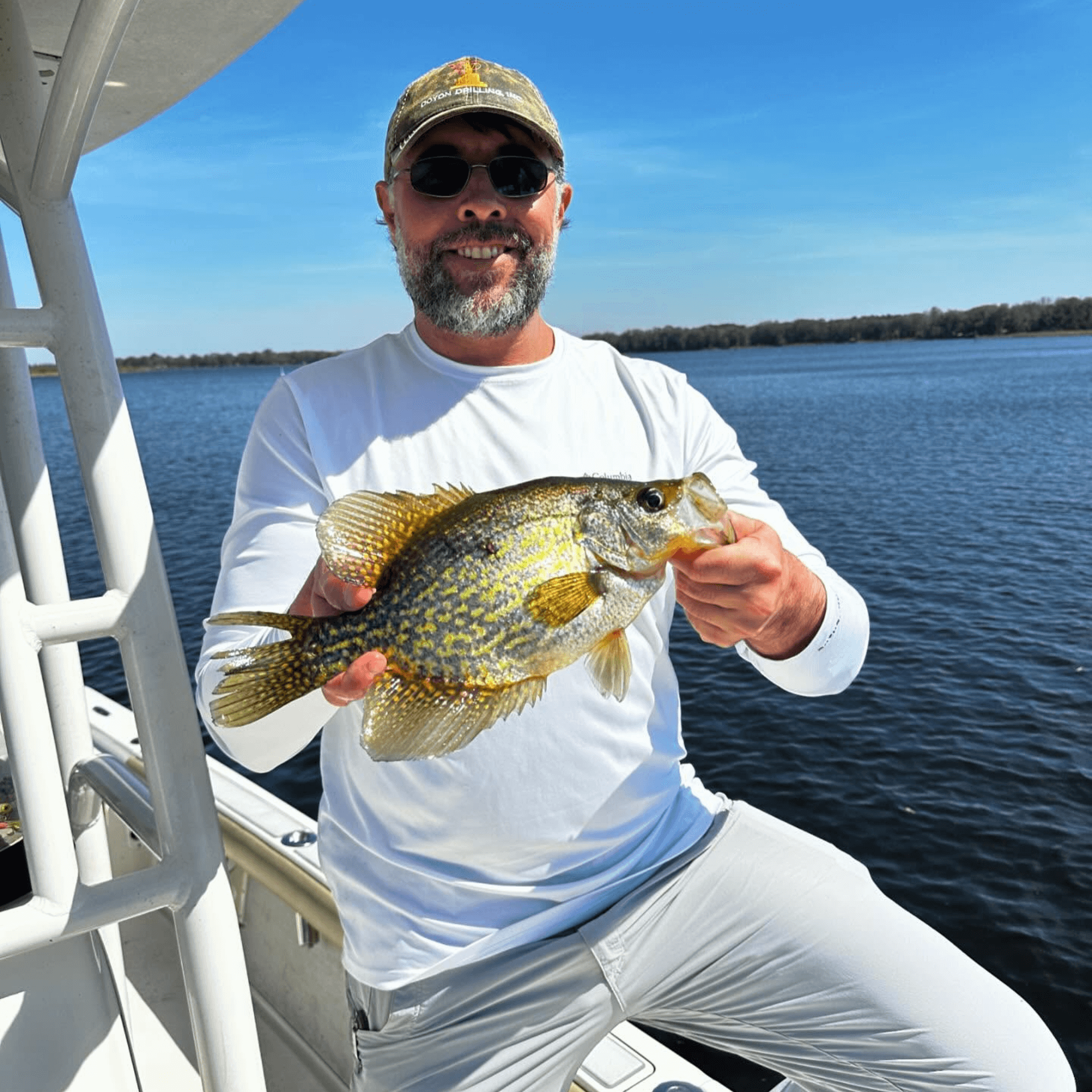 A man is sitting on a boat holding a fish