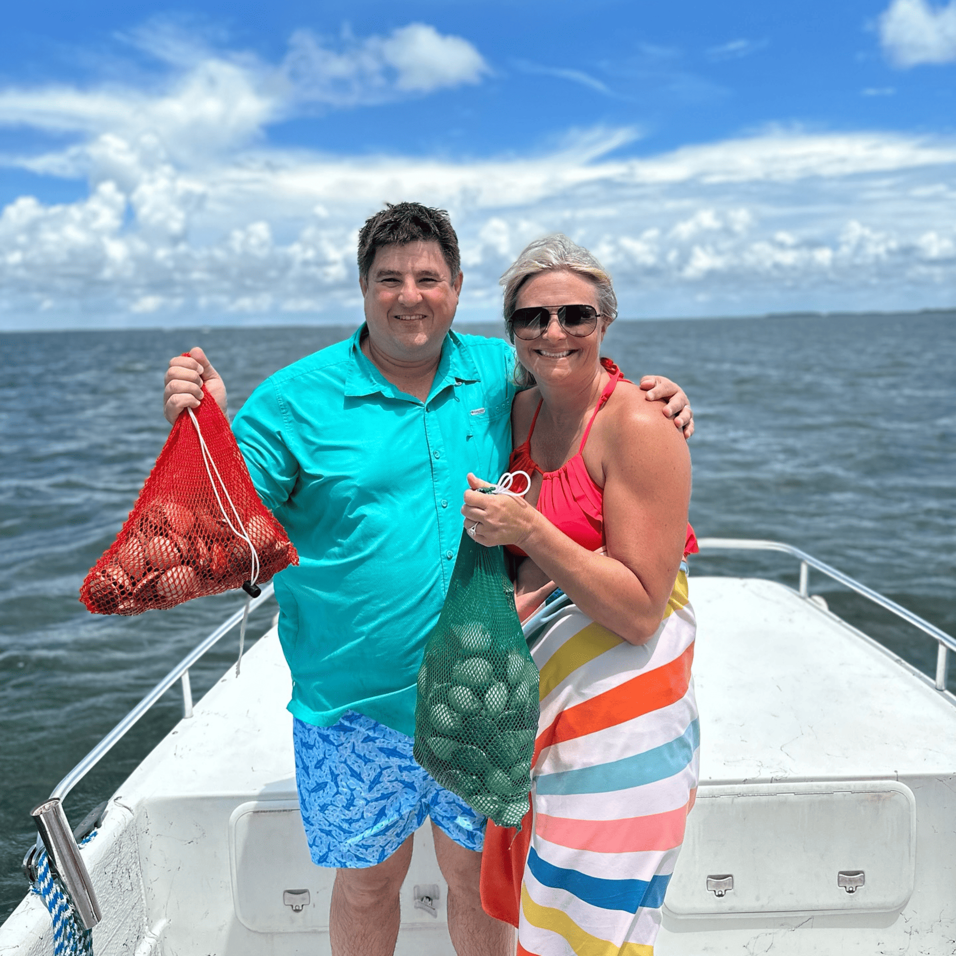 A man and a woman are standing on a boat holding a bag of clams.