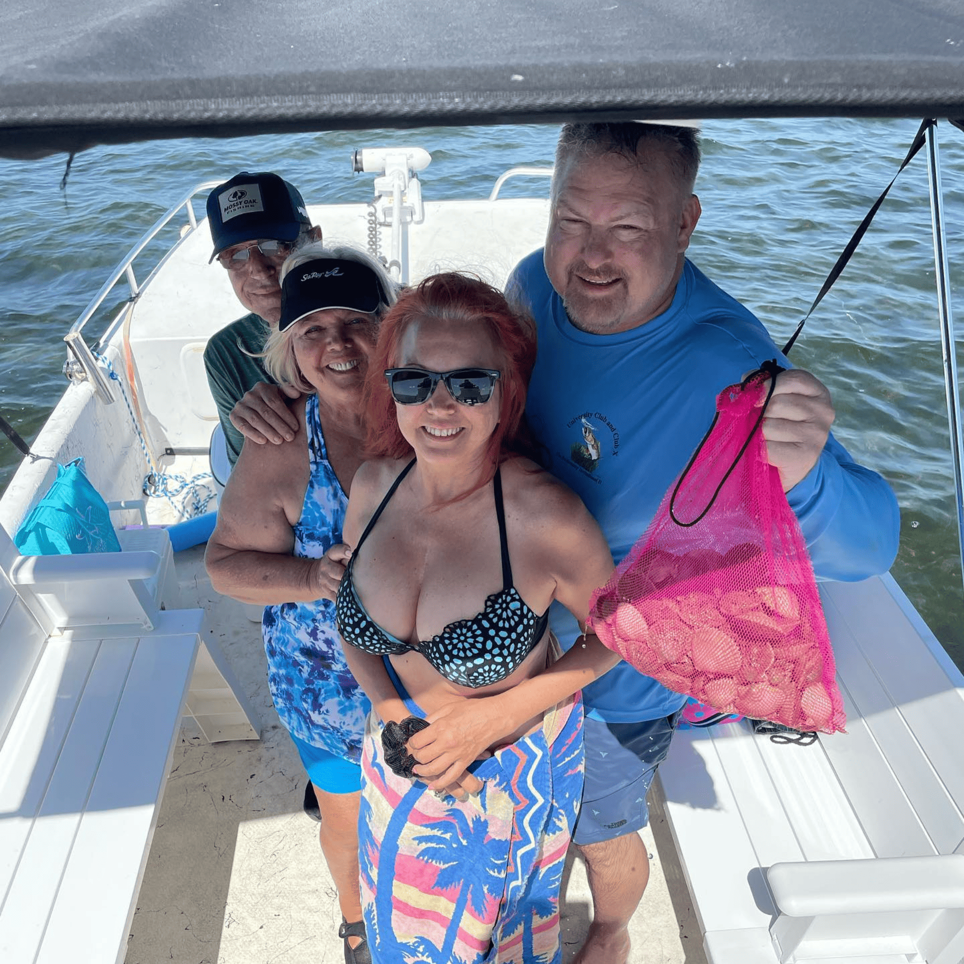 A group of people are posing for a picture on a boat scalloping