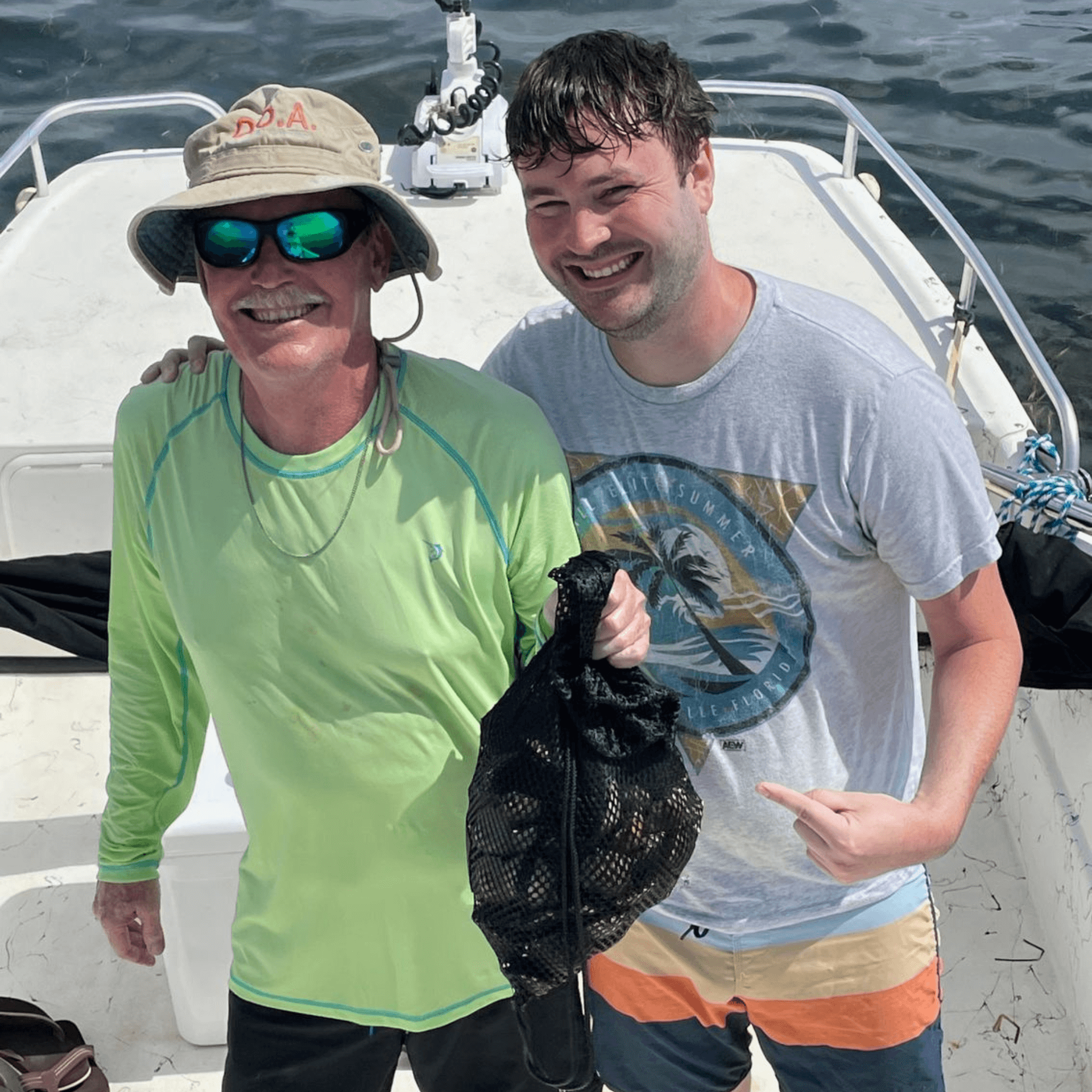 Two men are posing for a picture on a boat holding scallops