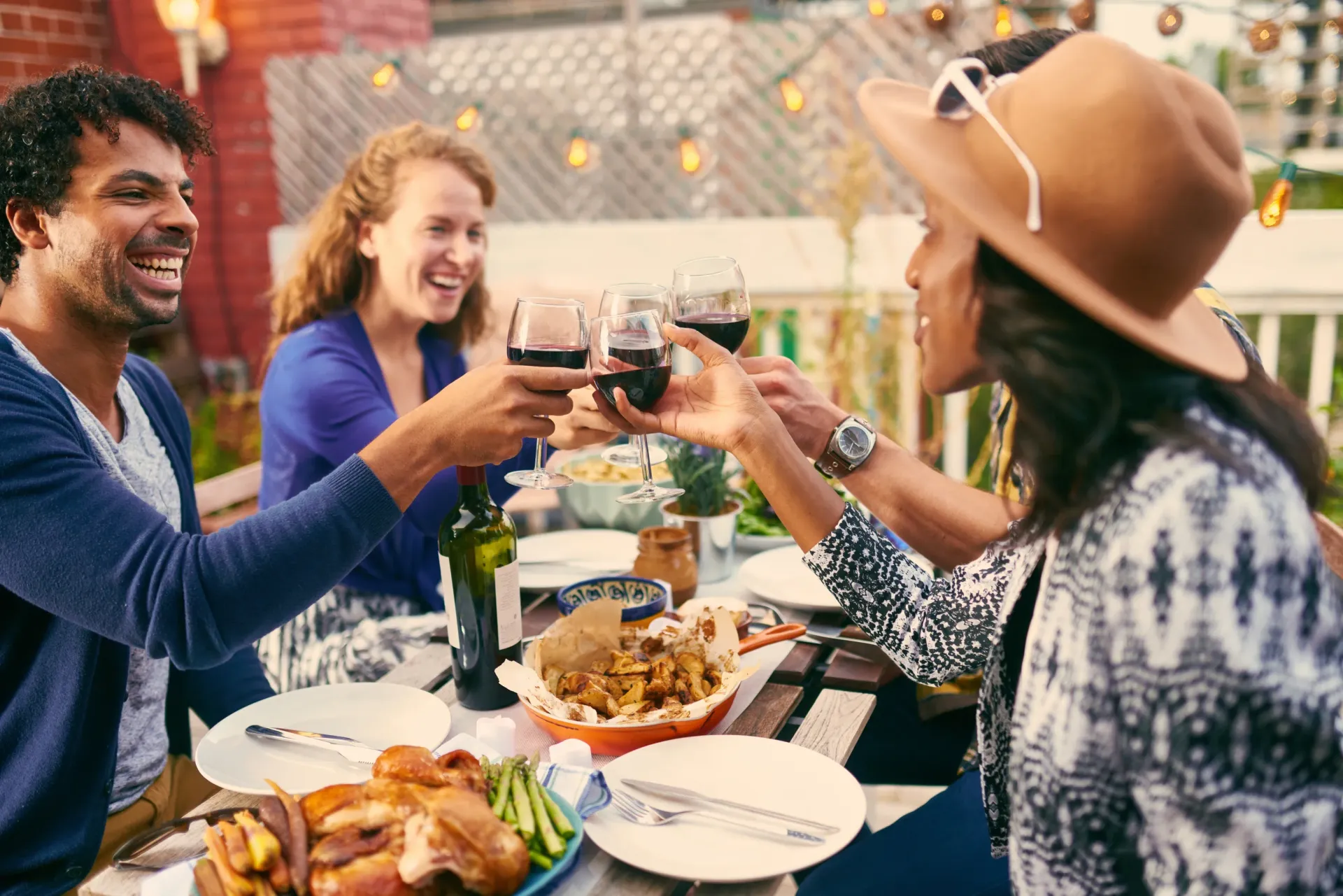 Friends toasting with wine during an outdoor dinner party.