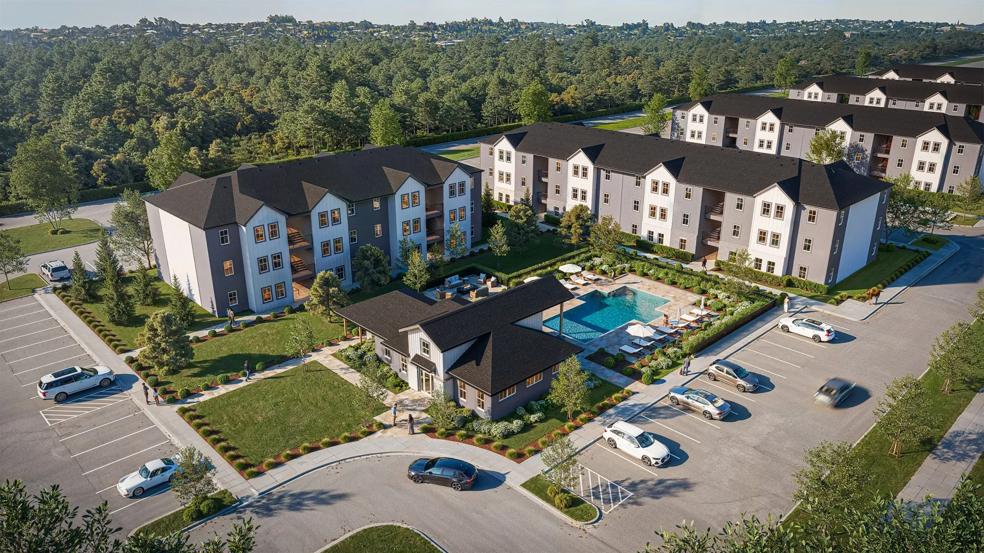 Aerial view of apartment buildings with a pool and parking lot.