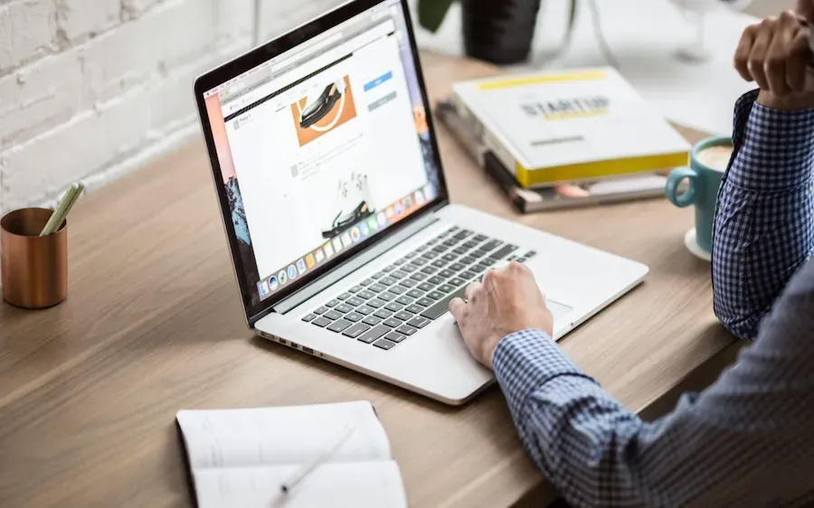 A man is sitting at a desk using a laptop computer.