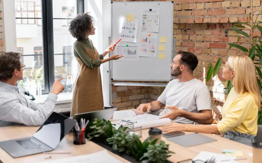 A woman is giving a presentation to a group of people in a conference room.