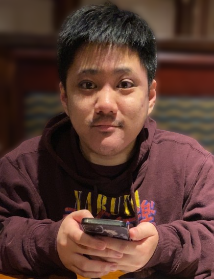 A man wearing a hoodie that says naruto is holding a cell phone