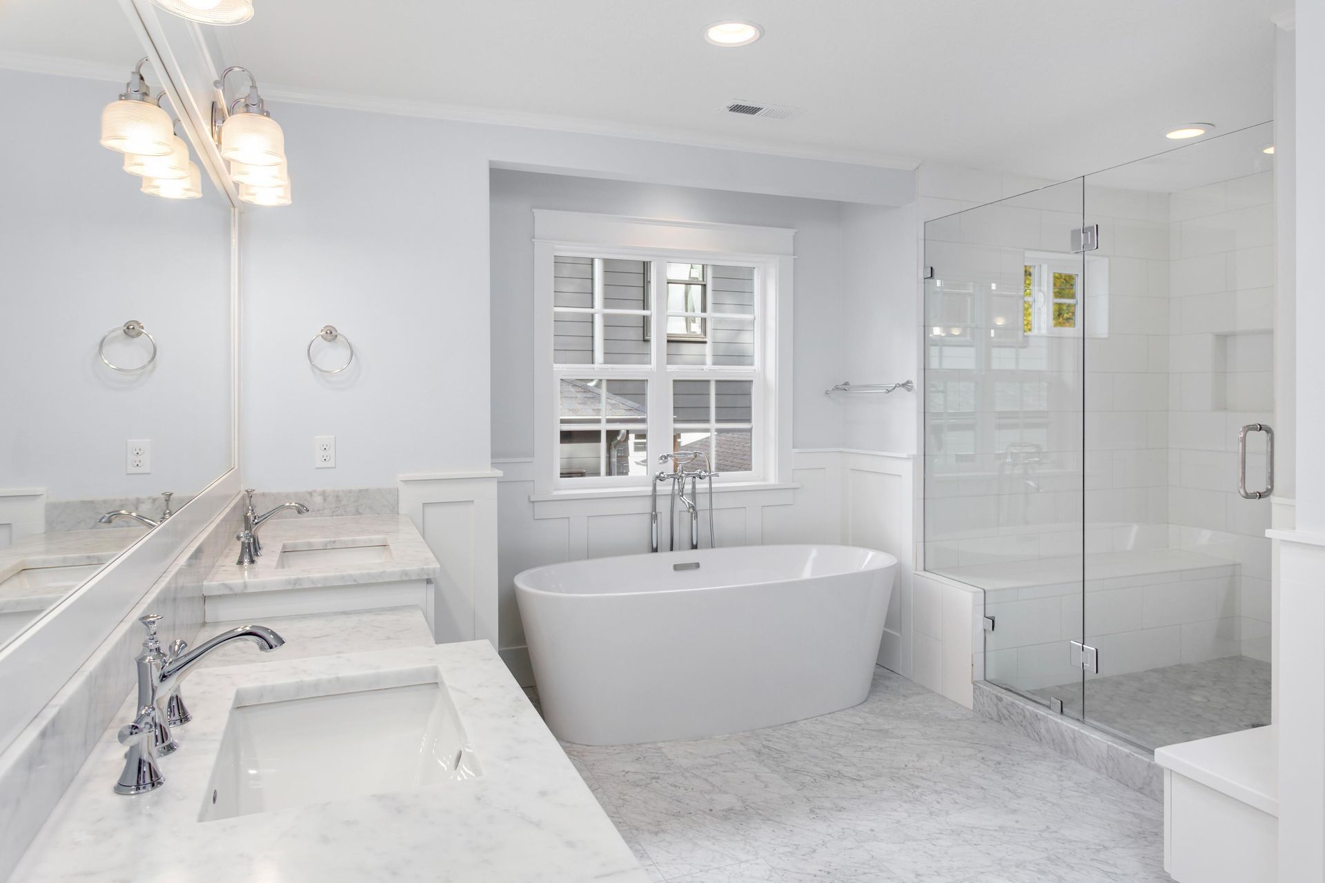 A bathroom with two sinks, a tub and a shower.
