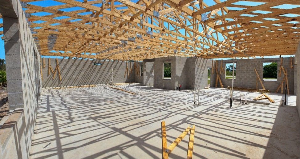 The inside of a building under construction with a wooden roof.
