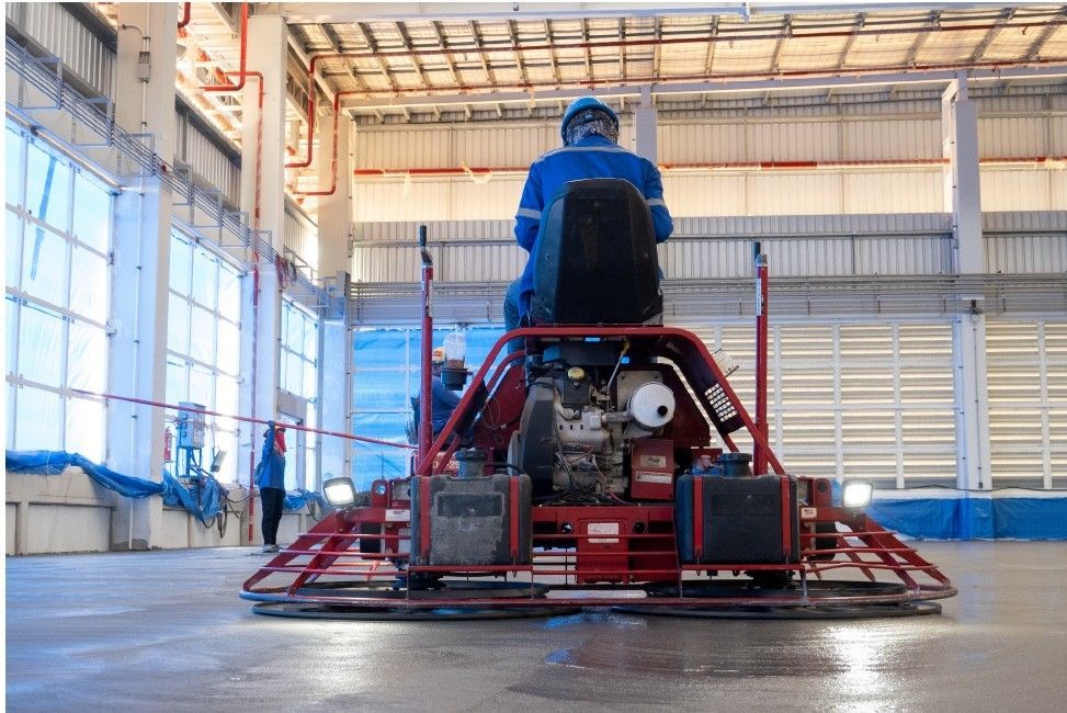 A man is riding a machine in a large warehouse.