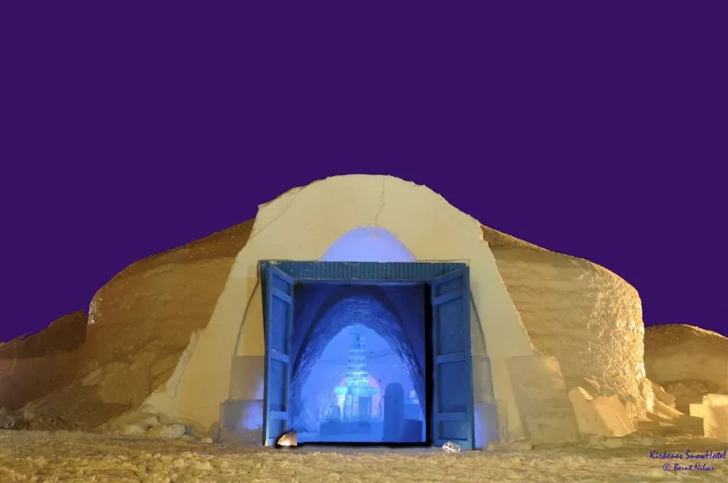 An igloo with a blue door and a blue sky in the background in Norway.