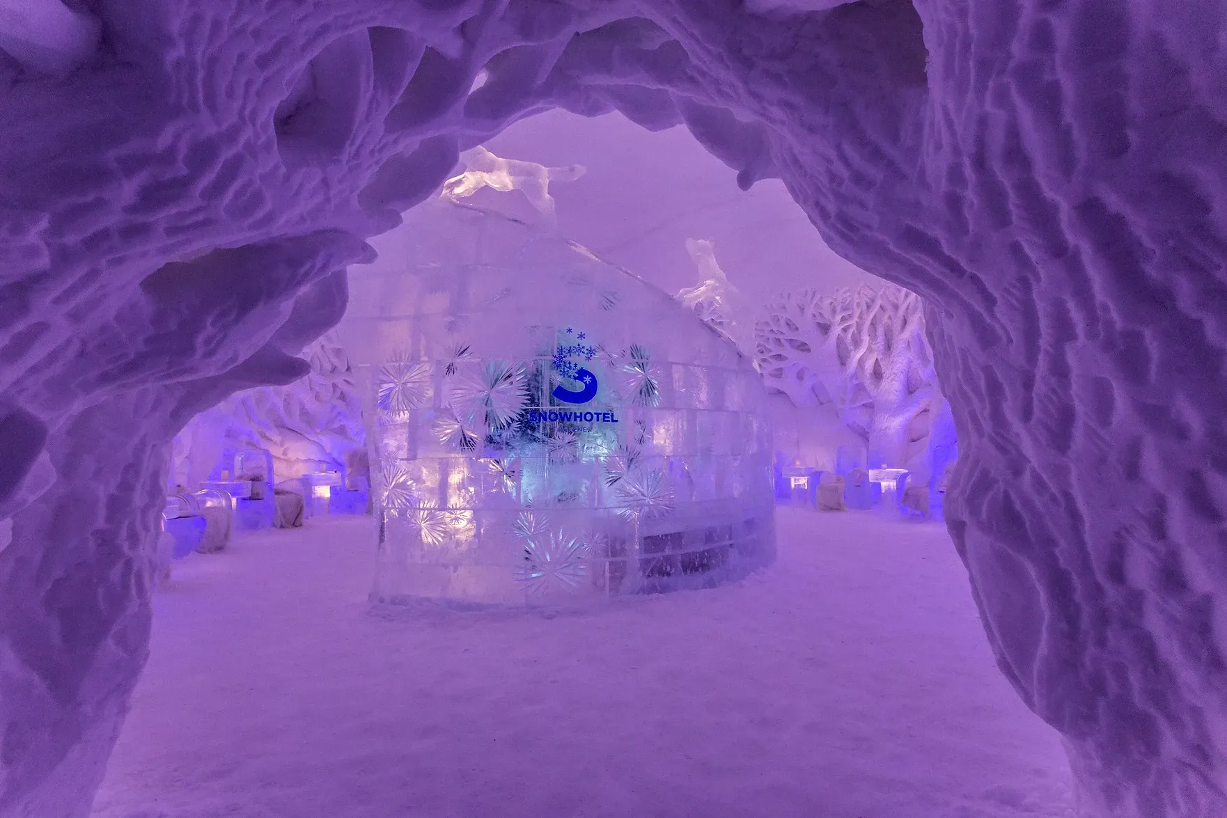 A purple tunnel with ice sculptures in it in an igloo in Norway.