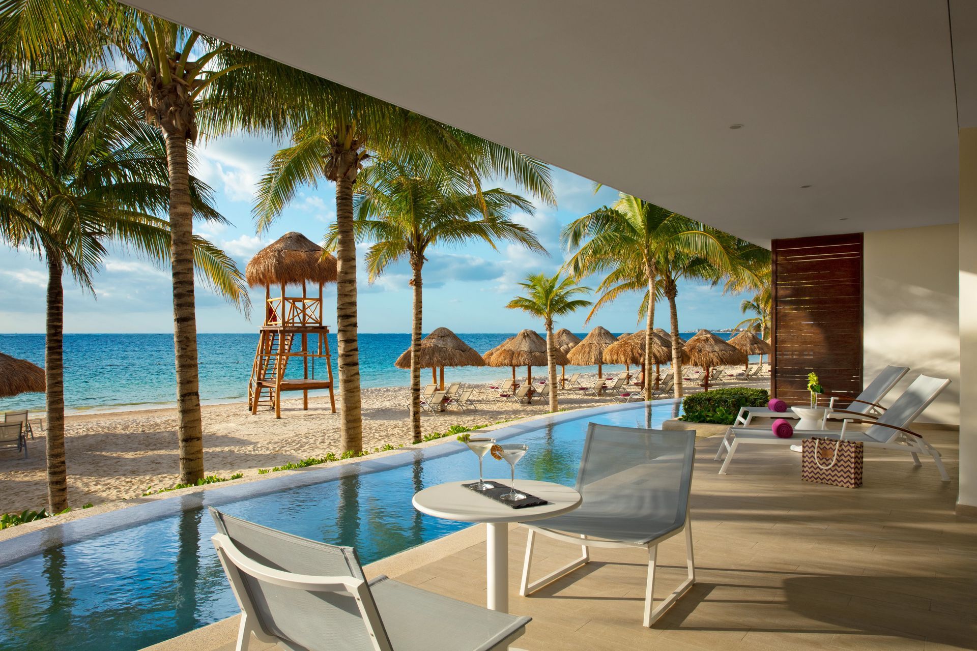 A view of a beach from a balcony overlooking a swimming pool at Breathless Rivera in Cancun.