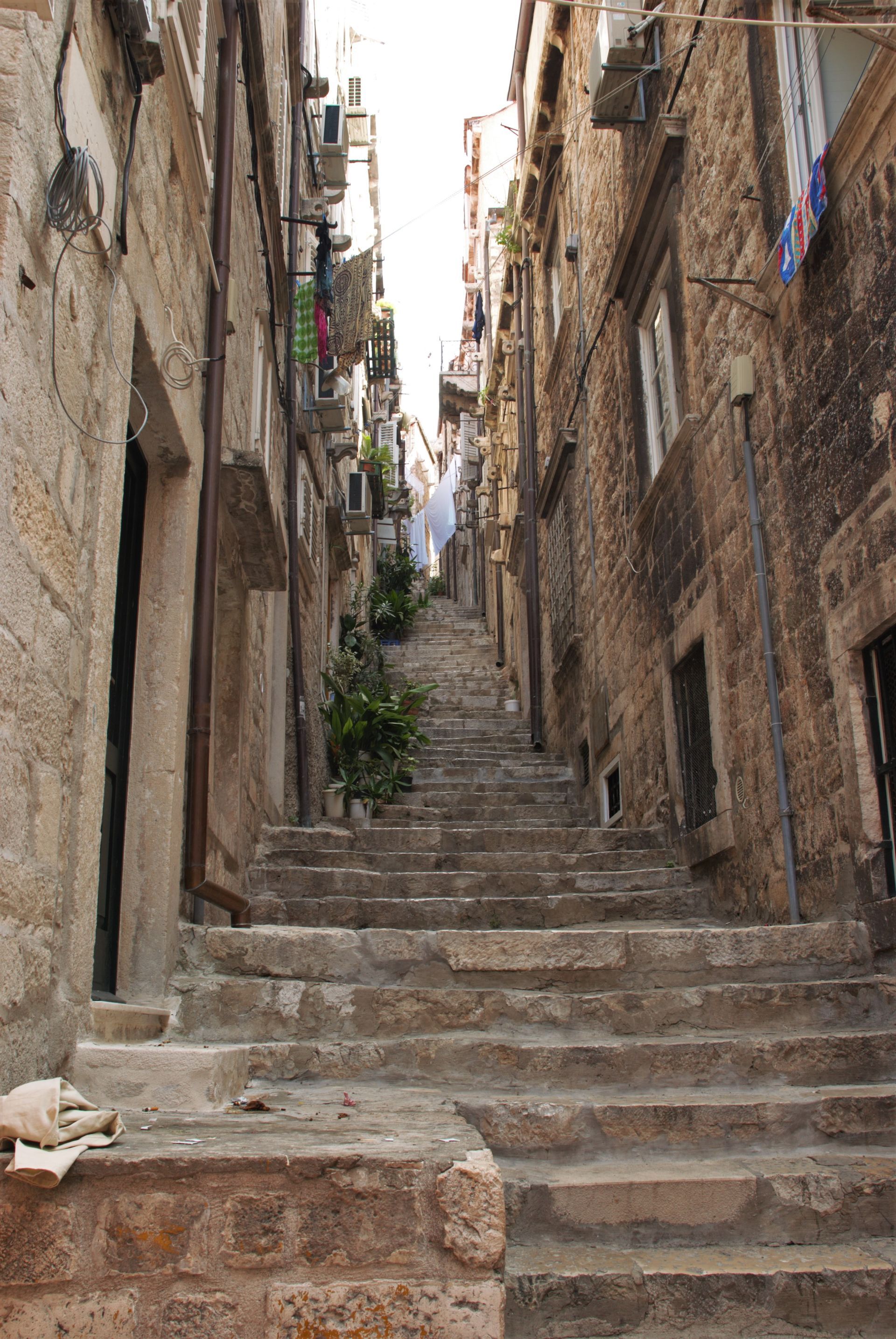 Stone staircase in a narrow alleyway with tall buildings on either side; Dubrovnik, Croatia.