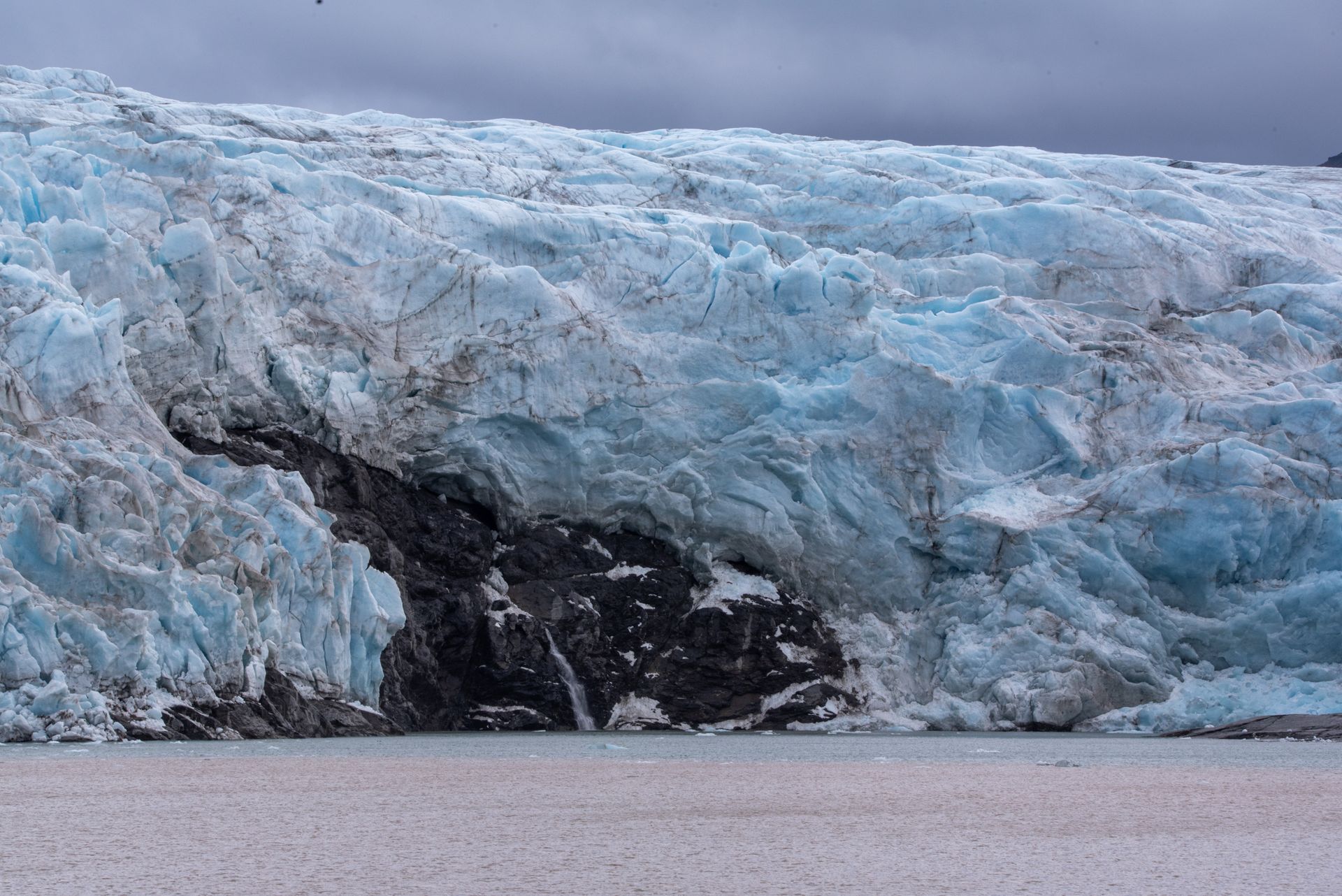 A large iceberg is sitting in the middle of a body of waterin Svalbard.